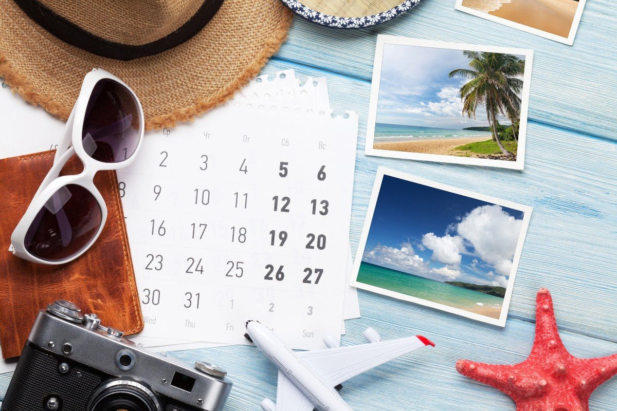 planning a vacation with sunglasses, calendar, camera and toy airplane
