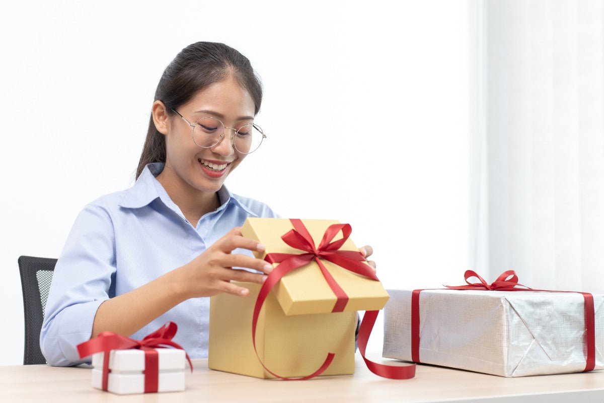 woman opening corporate gift for christmas in the office